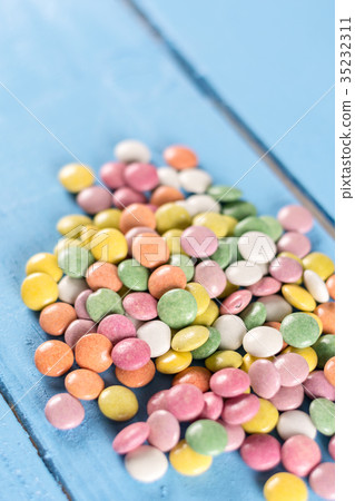 Pile of round colorful candies on the wooden table 35232311
