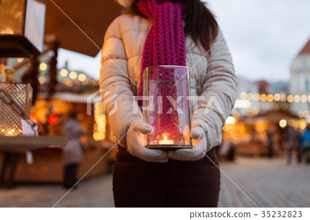 woman with candle in lantern at christmas market 35232823