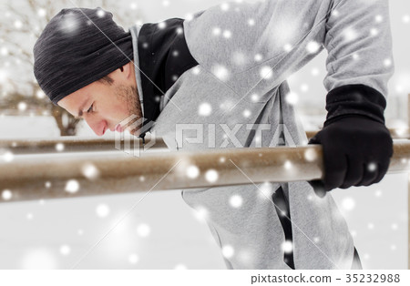 young man exercising on parallel bars in winter 35232988
