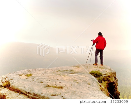 Photographr looking into viewfinder of dslr camera 35233099