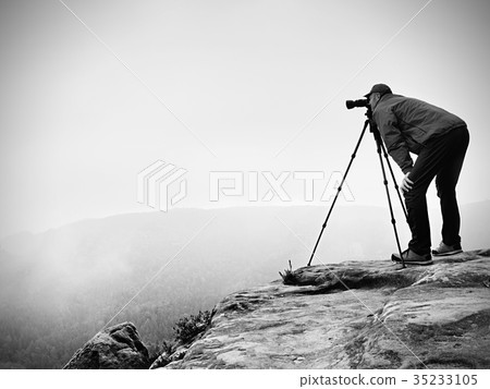 Wildlife photographer on mountain summit works 35233105