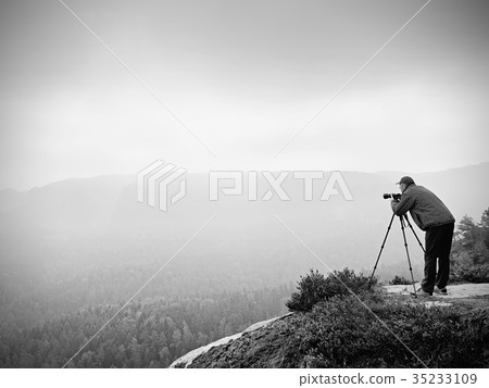 Photographer on summit works. Man like to travel 35233109