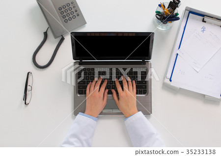 woman doctor hands typing on laptop at clinic 35233138