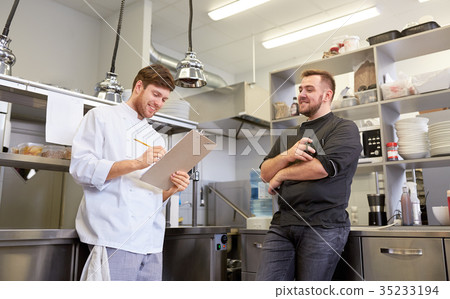 happy smiling chef and cook at restaurant kitchen 35233194