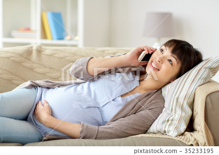 happy pregnant woman calling on smartphone at home 35233195