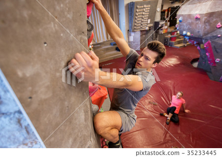 man and woman exercising at indoor climbing gym man and woman exercising at indoor climbing gym 35233445