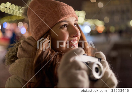 happy young woman with camera at christmas happy young woman with camera at christmas 35233446