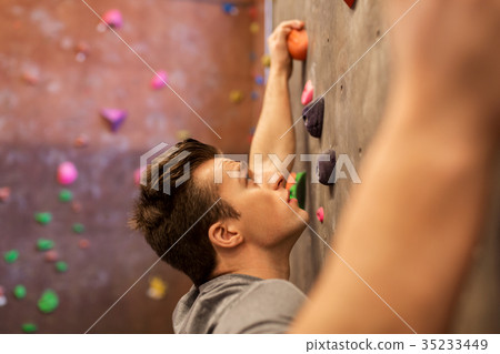 young man exercising at indoor climbing gym young man exercising at indoor climbing gym 35233449