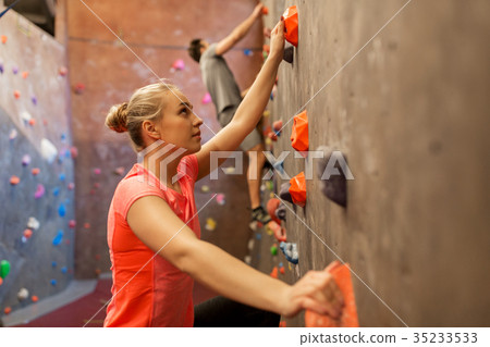 man and woman exercising at indoor climbing gym man and woman exercising at indoor climbing gym 35233533