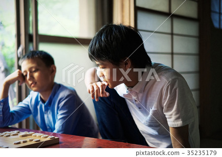 A boy studying Shogi 35235179