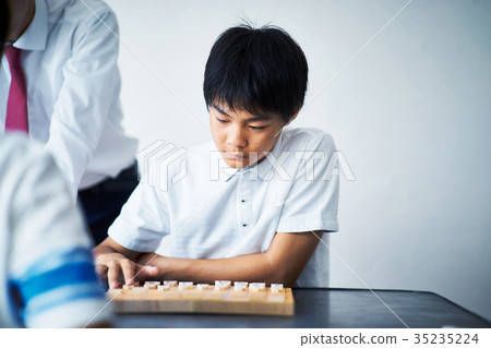 A boy studying Shogi 35235224