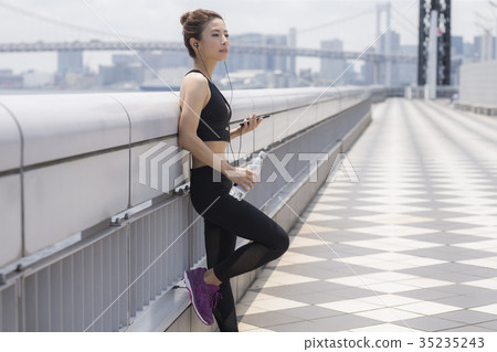 Woman in sportswear listening to music Woman in sportswear listening to music 35235243