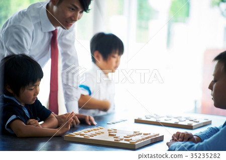 Men teaching shogi to children 35235282