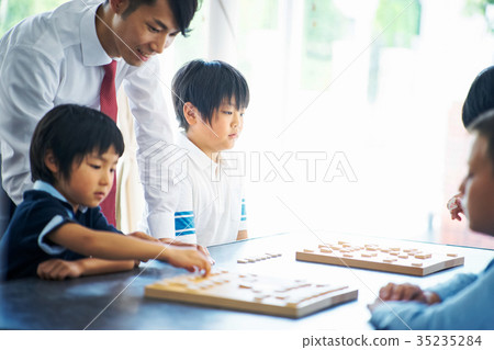 Men teaching shogi to children 35235284