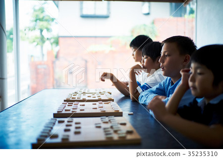 A boy studying Shogi 35235310