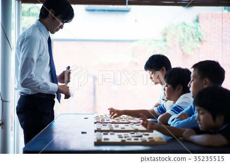 Men teaching shogi to children 35235515
