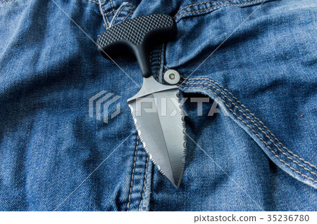 Neck knife on jeanse background. Diagonal. Neck knife on jeanse background. Diagonal. 35236780