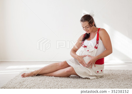 a pregnant woman sitting on the floor talking with 35238152