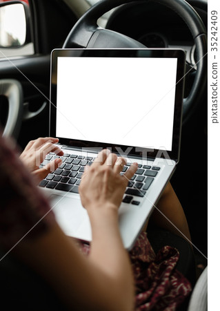 Anonymous woman browsing laptop in car 35242409