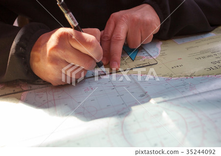 The ship's captain plans the route on a map 35244092