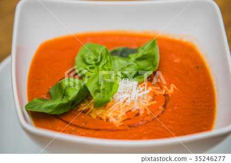 tomato creme soup and cheese on a wooden table 35246277