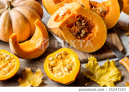 Sliced pumpkin with seeds on a wooden background Sliced pumpkin with seeds on a wooden background 35247291