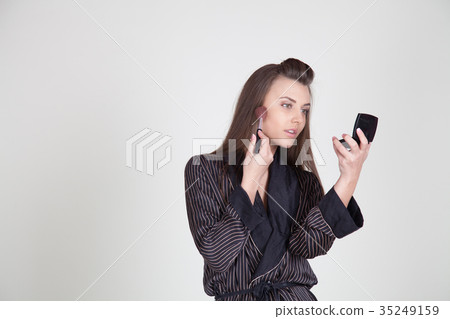 girl in coat makes brush makeup looks in the 35249159