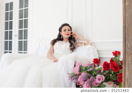 bride in a wedding dress and a crown sits in the bride in a wedding dress and a crown sits in the 35251483