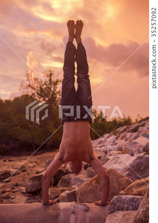 Young Caucasian man is hand balancing Young Caucasian man is hand balancing 35257092