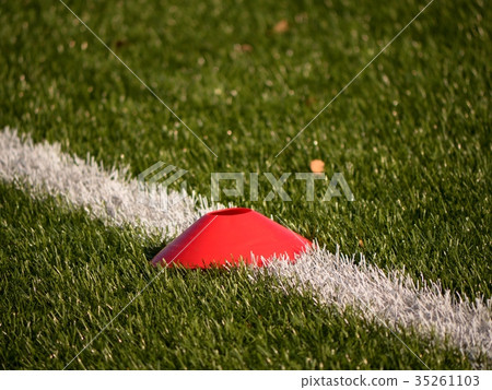 Bright red plastic cone on painted white line Bright red plastic cone on painted white line 35261103