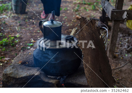 Close up camping fire with pot and metal mug 35262462