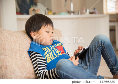 Kids doing smartphones in the living room Kids doing smartphones in the living room 35266880