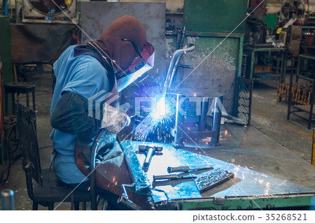 Man is welding an automotive part. Man is welding an automotive part. 35268521