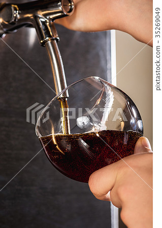 Hand of bartender pouring a large lager beer in Hand of bartender pouring a large lager beer in 35269049