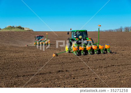 Farmer with tractor seeding - sowing crops 35271258