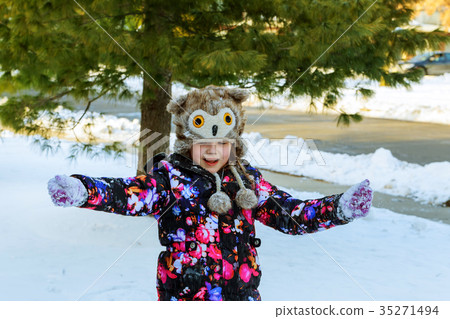 Cute little girl playing with snow in winter park 35271494