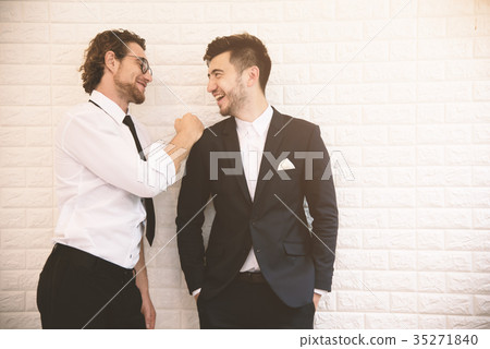 Two young smart businessmen talking together during leisure time 35271840