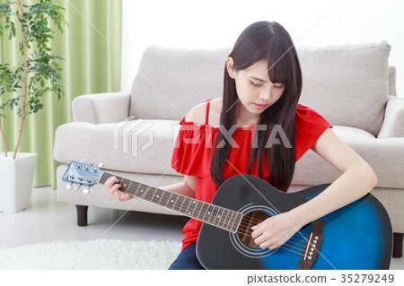 A guitar playing young lady A guitar playing young lady 35279249