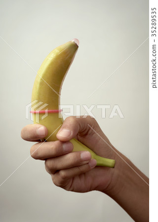 man holding a banana with a condom 35289535