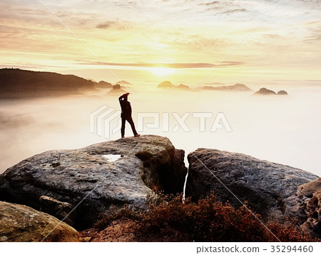 Man silhouette stay on rock peak. Man on cliff Man silhouette stay on rock peak. Man on cliff 35294460