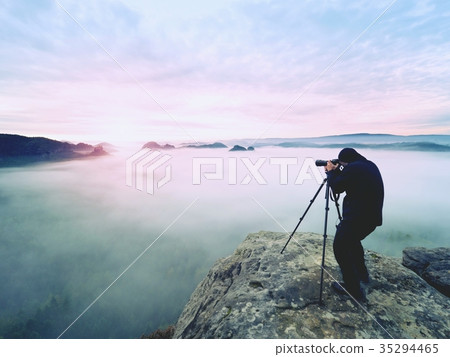 Professional on cliff. Nature photographer works 35294465