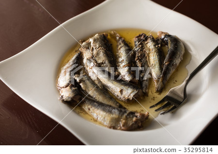 Marinated sardines in oil served on a white plate Marinated sardines in oil served on a white plate 35295814