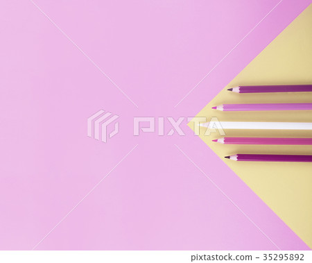 Colored pencils on pink and yellow background. 35295892