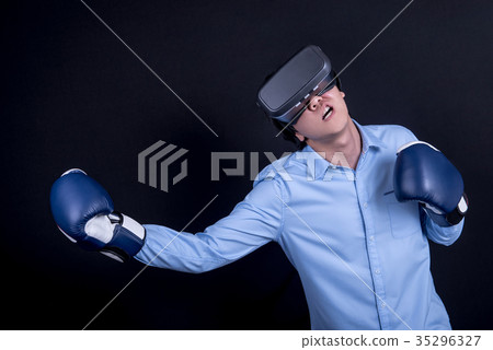 Man wear virtual reality goggles and boxing gloves Man wear virtual reality goggles and boxing gloves 35296327