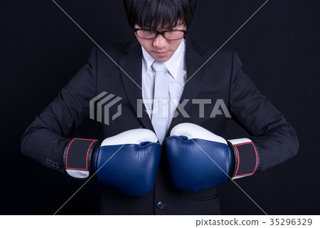 young business man wearing suit with boxing gloves young business man wearing suit with boxing gloves 35296329