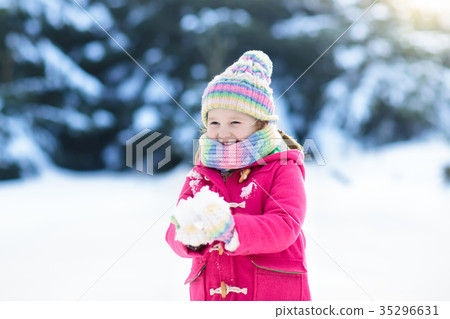 Child playing with snow in winter. Kids outdoors. 35296631