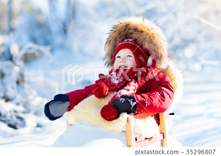 Sled and snow fun for kids. Baby sledding in park. Sled and snow fun for kids. Baby sledding in park. 35296807