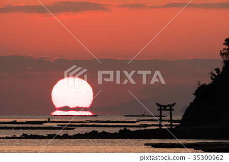 Daruma Asahi rising from an island with a torii in the Seto Inland Sea 35300962