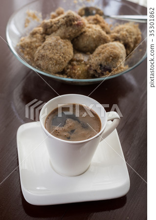 White cup of coffee with plum dumplings 35301862
