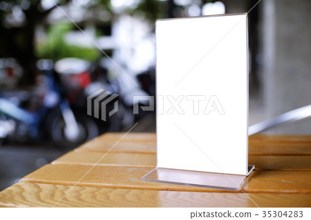 Mock up Menu frame standing on wood table in Bar Mock up Menu frame standing on wood table in Bar 35304283